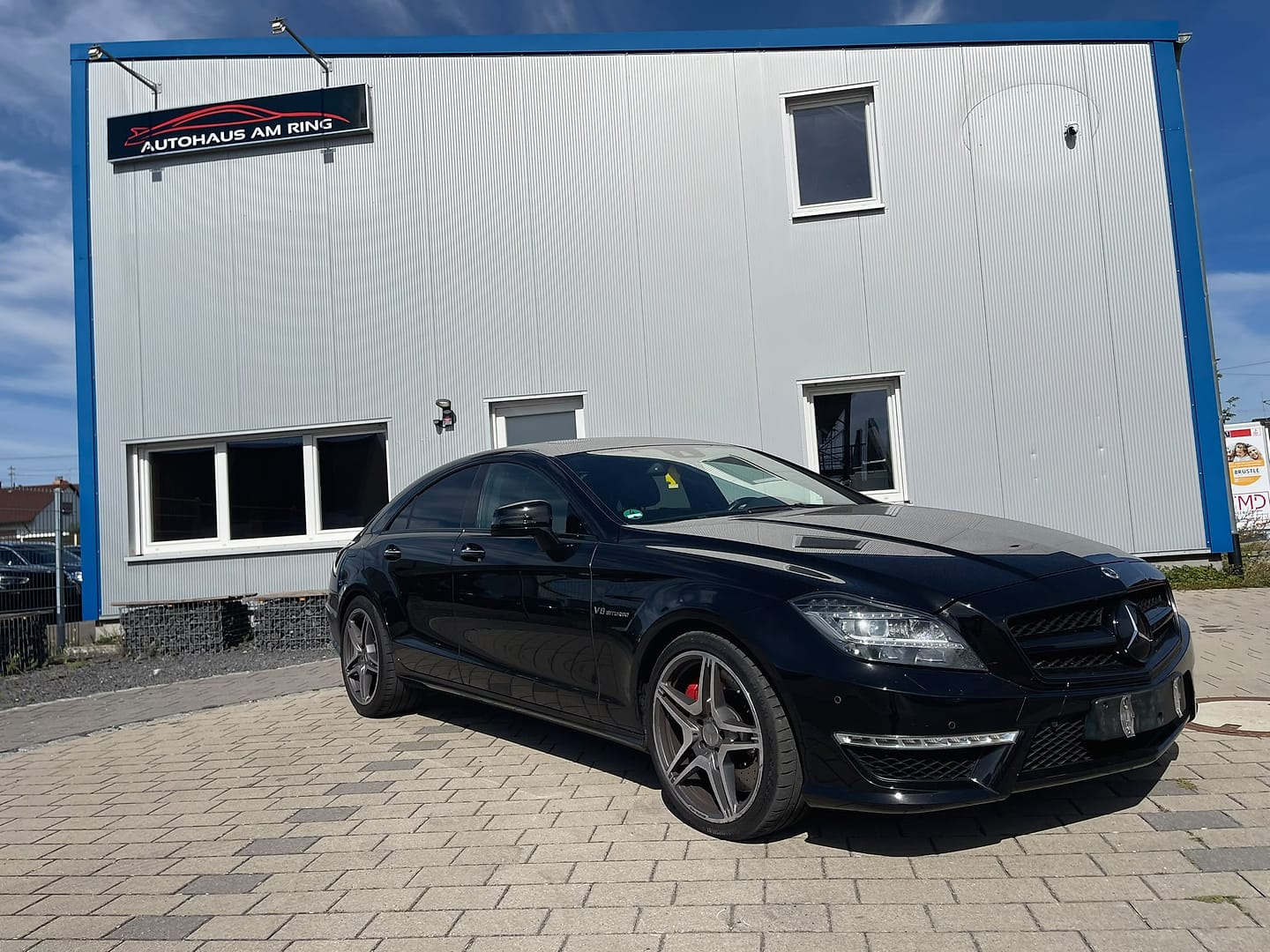Mercedes-Benz CLS 63 AMG in Schwarz, schräg von vorn, vor der Halle in Illingen