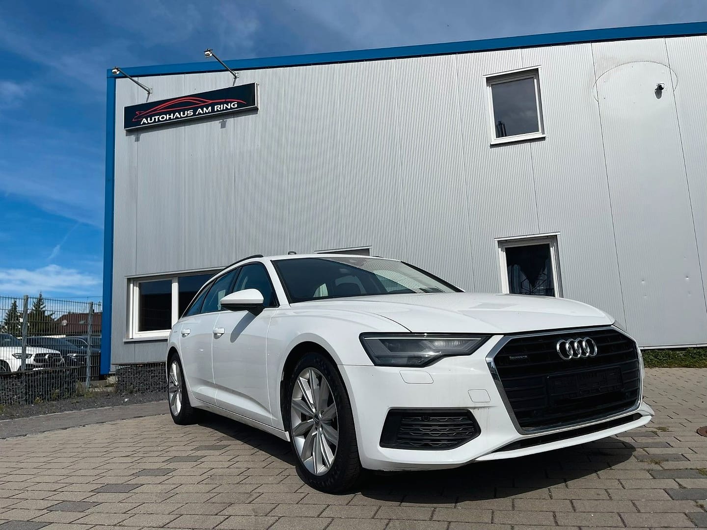 Audi A6 Avant 45 TDI quattro sport, schräg von vorn, vor der Halle in Illingen