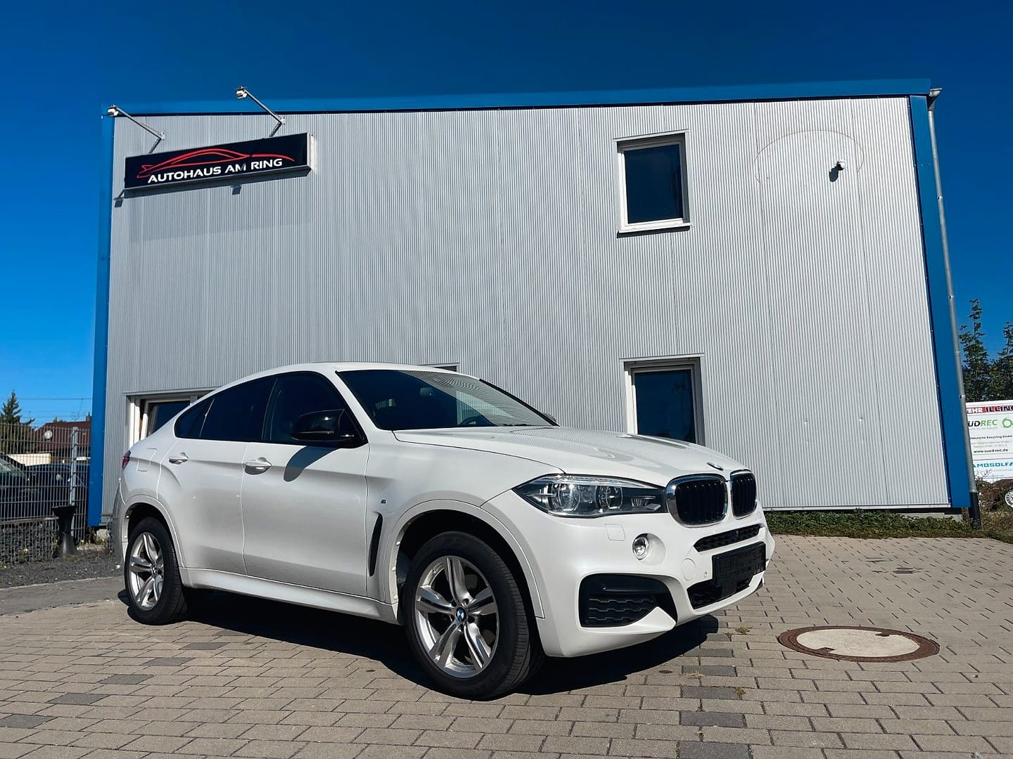 BMW X6 xDrive 30 d M Paket, schräg von vorn, vor der Halle in Illingen