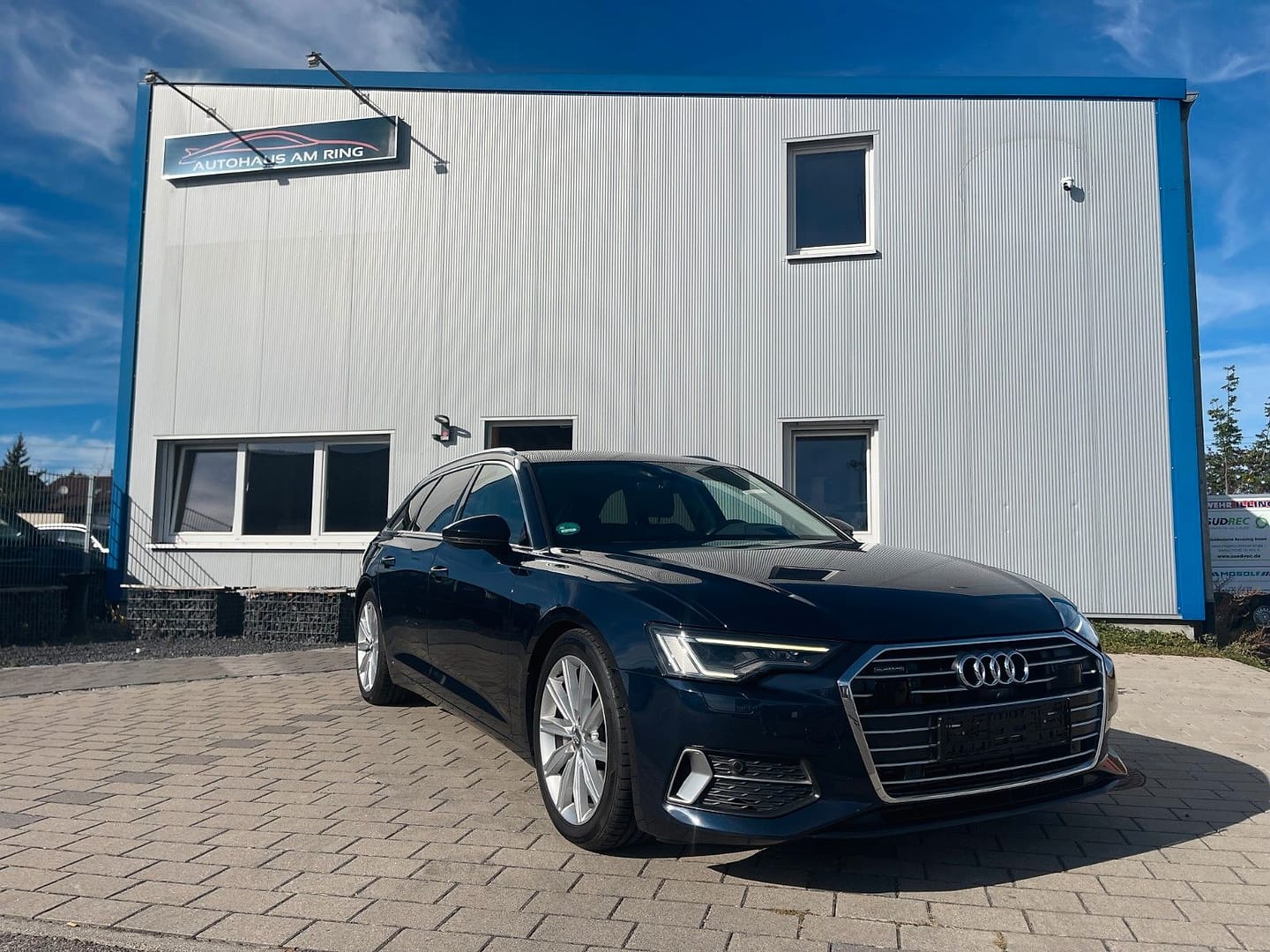 Audi A6 Avant 50 TDI quattro sport, schräg von vorn, vor der Halle in Illingen