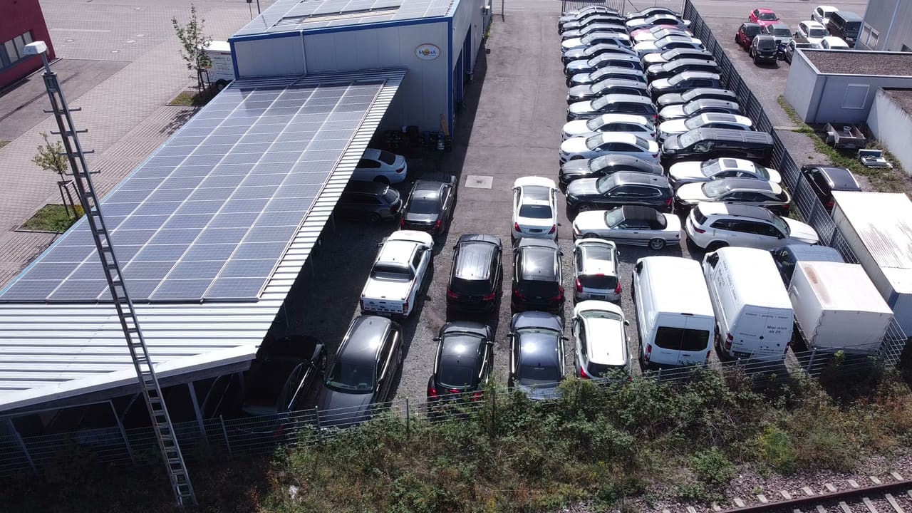 Luftaufnahme der Halle mit Photovoltaik-Dach und der Fahrzeugreihen an der Luigstraße